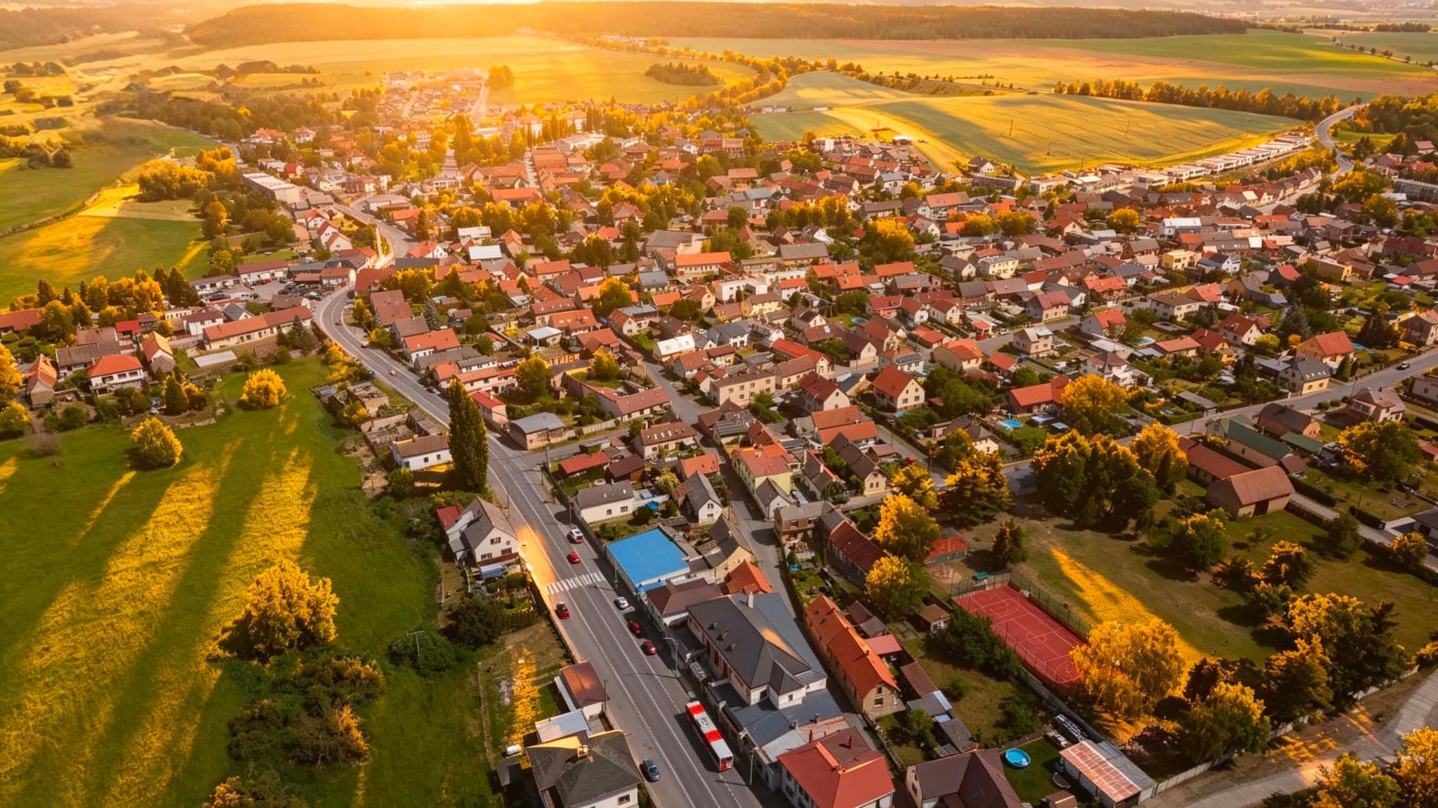 Brodce z ptačí perspektivy — červené střechy a zahrady v létě